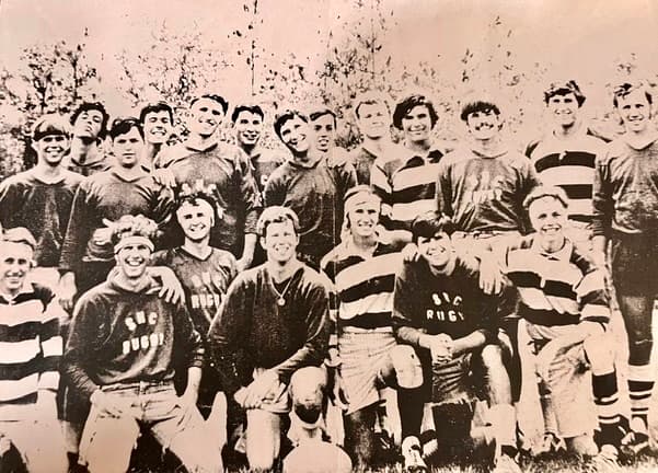 Black-and-white photo of an early Spring Hill rugby side in hand-lettered SHC Rugby shirts, lined up on the field