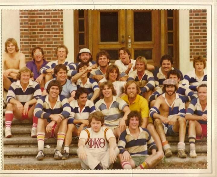 Color photo of the 1970s squad crowded onto the brick front steps on campus after a match